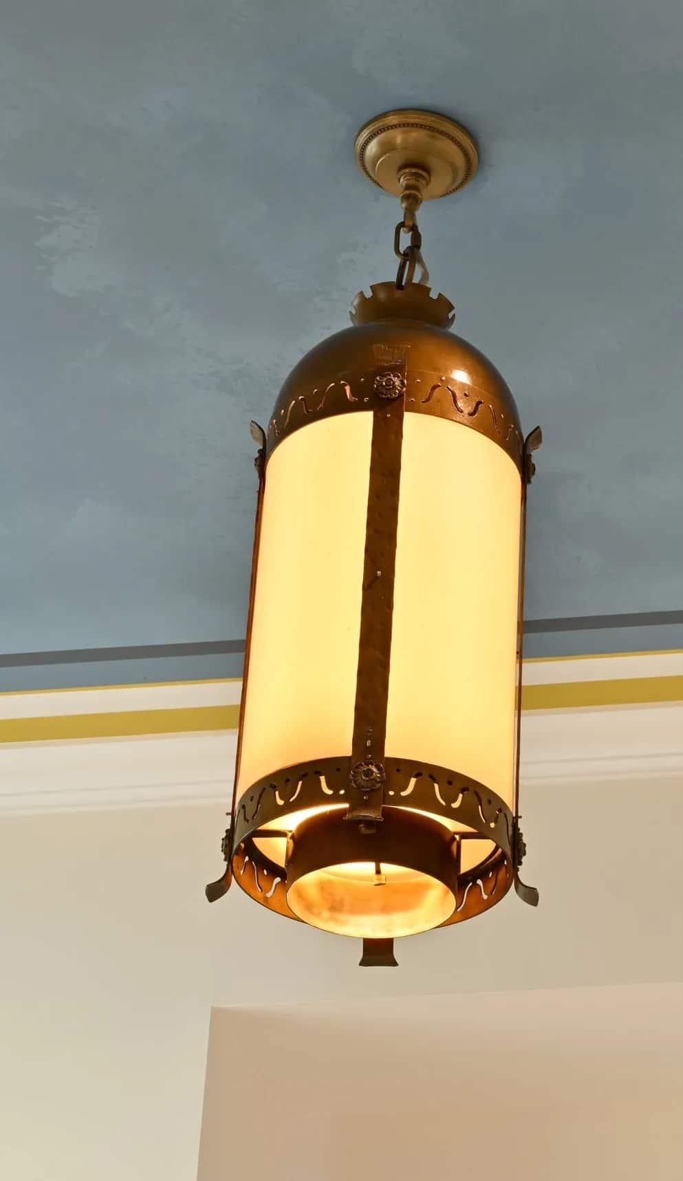 A single lit lantern hanging down from the wall